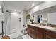 Well-lit bathroom featuring double sinks, granite counters, and a walk-in shower at 5043 White Chicory Dr, Apollo Beach, FL 33572