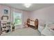 Charming bedroom with light pink walls and a crib, perfect for a Bedroom at 5043 White Chicory Dr, Apollo Beach, FL 33572