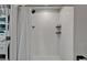 White tiled shower featuring built in shelves and a glass door at 5043 White Chicory Dr, Apollo Beach, FL 33572