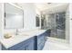 Elegant bathroom boasts blue cabinets, dual sinks, and a luxurious black marble walk-in shower at 5212 62Nd S Ave, St Petersburg, FL 33715