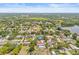 Scenic aerial view of a home with a pool, set amidst mature trees and near a tranquil lake at 603 Royal Crest Dr, Brandon, FL 33511
