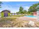 Full backyard view with a shed, a large rectangular pool, and a vibrant color scheme at 603 Royal Crest Dr, Brandon, FL 33511