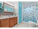 Charming bathroom with seashell wallpaper, wooden cabinets, and a shower featuring a decorative curtain at 603 Royal Crest Dr, Brandon, FL 33511