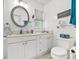 Bathroom with double sinks, a framed round mirror, and a toilet at 603 Royal Crest Dr, Brandon, FL 33511
