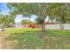 Charming coral-colored home featuring a well-maintained lawn, mature trees, and a white picket fence at 603 Royal Crest Dr, Brandon, FL 33511