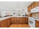 Bright open kitchen featuring wooden cabinetry, tile backsplash and white appliances at 603 Royal Crest Dr, Brandon, FL 33511