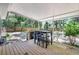 Covered back porch features a wooden deck and a black dining set with chairs at 706 S 56Th St, Tampa, FL 33619