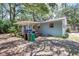 Landscape view of the rear of the property showing the backyard, covered porch, and mature shade trees at 706 S 56Th St, Tampa, FL 33619