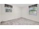 Neutral bedroom features two light-filled windows and neutral carpeting at 706 S 56Th St, Tampa, FL 33619