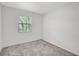 Cozy bedroom features soft carpet and natural light from an exterior window at 706 S 56Th St, Tampa, FL 33619