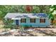 Charming single-story home with blue siding, black shutters and mature trees at 706 S 56Th St, Tampa, FL 33619