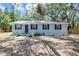 Charming single-story home with light blue siding and black shutters surrounded by mature trees at 706 S 56Th St, Tampa, FL 33619