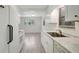 Open kitchen with white cabinets, stainless steel sink, and view into the adjacent living space at 706 S 56Th St, Tampa, FL 33619