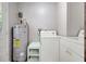 Bright laundry room with washer, dryer, and newer hot water heater at 706 S 56Th St, Tampa, FL 33619