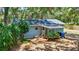 Rear exterior of light blue home, featuring a covered patio, wooden deck, and backyard at 706 S 56Th St, Tampa, FL 33619
