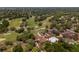 Overhead view of the golf course, pool, clubhouse, and tennis/pickleball courts at 7535 Greystone Dr, Hudson, FL 34667