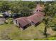 Aerial view of home nestled among trees with a brown roof at 7535 Greystone Dr, Hudson, FL 34667