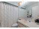 Bathroom with neutral cabinet and white floral curtained tub and shower at 7535 Greystone Dr, Hudson, FL 34667