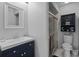 Modern bathroom with blue vanity, white sink, mirror, and glass shower at 7535 Greystone Dr, Hudson, FL 34667
