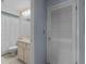 Neutral toned bathroom featuring an enclosed toilet and light cabinets at 7535 Greystone Dr, Hudson, FL 34667
