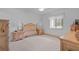 Bright bedroom with ceiling fan, white walls, carpet floors, and natural wood furniture at 7535 Greystone Dr, Hudson, FL 34667