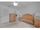 Bright bedroom featuring neutral carpet, wood dresser, bedside table and ceiling fan at 7535 Greystone Dr, Hudson, FL 34667