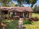 Charming home with inviting front porch featuring rocking chairs and beautiful landscaping at 7535 Greystone Dr, Hudson, FL 34667