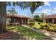 Beautifully landscaped home with inviting front porch featuring rocking chairs, perfect for relaxation at 7535 Greystone Dr, Hudson, FL 34667