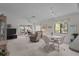 Spacious living room featuring neutral carpet, large windows and a dining area with seating for four at 7535 Greystone Dr, Hudson, FL 34667