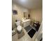 Bathroom view with a white sink, white toilet, gray mats, and a few bathroom accessories at 7620 32Nd S Ave, Tampa, FL 33619