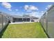 Expansive fenced backyard with manicured lawn and covered lanai at 8421 Ivy Stark Blvd, Wesley Chapel, FL 33545