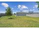Large fenced backyard with a lush green lawn and young trees at 8421 Ivy Stark Blvd, Wesley Chapel, FL 33545