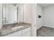 Granite counters accent the bathroom, with a sink, mirror and neutral walls at 8421 Ivy Stark Blvd, Wesley Chapel, FL 33545