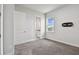 Bedroom with carpet flooring, TV mount, and view to the bathroom at 8421 Ivy Stark Blvd, Wesley Chapel, FL 33545