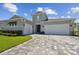 Beautiful home exterior showcasing a paved driveway, three-car garage, and manicured landscaping at 8421 Ivy Stark Blvd, Wesley Chapel, FL 33545