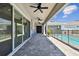 Paver patio with fans, door, sliders, and safety fence around pool at 8421 Ivy Stark Blvd, Wesley Chapel, FL 33545