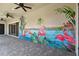 Covered patio with ceiling fans and a hand painted flamingo mural at 8421 Ivy Stark Blvd, Wesley Chapel, FL 33545