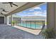 View of a fenced pool from covered patio with ceiling fans and pavers at 8421 Ivy Stark Blvd, Wesley Chapel, FL 33545
