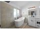 Luxury bathroom showcasing a freestanding tub, tiled shower, and a granite-topped vanity with modern fixtures at 8820 Cypress Hammock Dr, Tampa, FL 33614