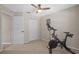 This bedroom features a stationary bicycle, a ceiling fan, and neutral colored walls at 8820 Cypress Hammock Dr, Tampa, FL 33614