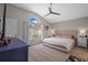Comfortable main bedroom with vaulted ceiling, fan, carpet and large window with view to backyard at 8820 Cypress Hammock Dr, Tampa, FL 33614
