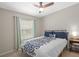 A comfortable bedroom has a ceiling fan, a side table with a lamp and a window at 8820 Cypress Hammock Dr, Tampa, FL 33614