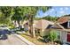 A charming yellow single-Gathering home boasting meticulous landscaping and a neatly manicured lawn at 8820 Cypress Hammock Dr, Tampa, FL 33614