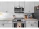 Updated kitchen features stainless steel appliances, white cabinets, granite countertops, and a stylish subway tile backsplash at 8820 Cypress Hammock Dr, Tampa, FL 33614