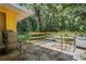 Outdoor patio area with chairs and natural shade from mature trees, perfect for relaxing at 8828 Jasmine Blvd, Port Richey, FL 34668
