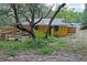 Exterior backyard view of a yellow home with mature trees and green landscape at 8828 Jasmine Blvd, Port Richey, FL 34668