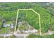Aerial view of the approximate land parcel outline, highlighting its location near lush woods and a road at 8828 Jasmine Blvd, Port Richey, FL 34668