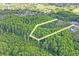 Aerial view showing approximate outline of the lot within a wooded area at 8828 Jasmine Blvd, Port Richey, FL 34668
