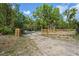 Gated property entrance bordered by wooden fences, enhancing security and privacy at 8828 Jasmine Blvd, Port Richey, FL 34668