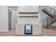 A bar area featuring floating shelves, a beverage refrigerator, and white cabinetry complements the modern staircase design at 910 W Virginia Ave, Tampa, FL 33603